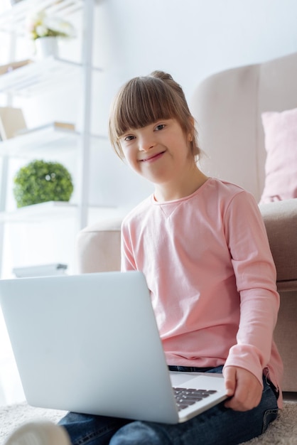 Niño sonriente con síndrome de Down usando una computadora portátil