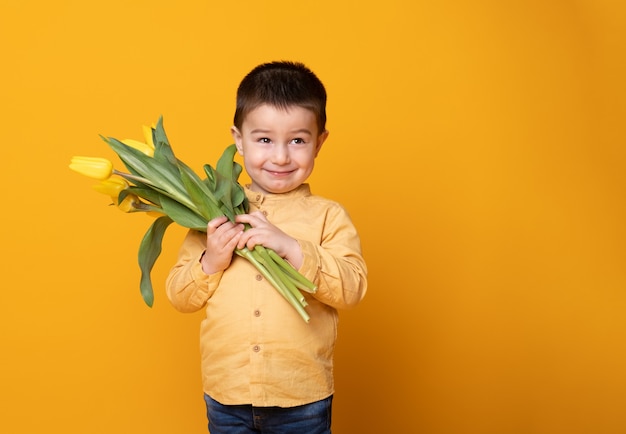 Niño sonriente sobre fondo amarillo studio