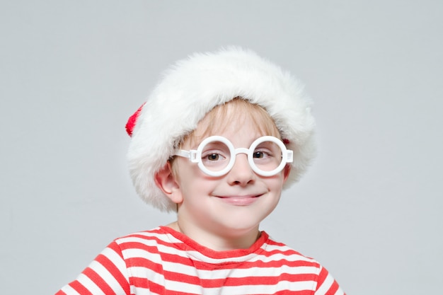 Niño sonriente con sombrero de Santa y gafas. Retrato