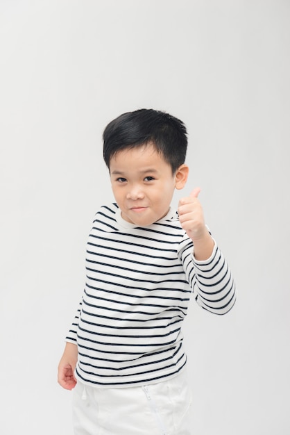 Niño sonriente sosteniendo su pulgar hacia arriba