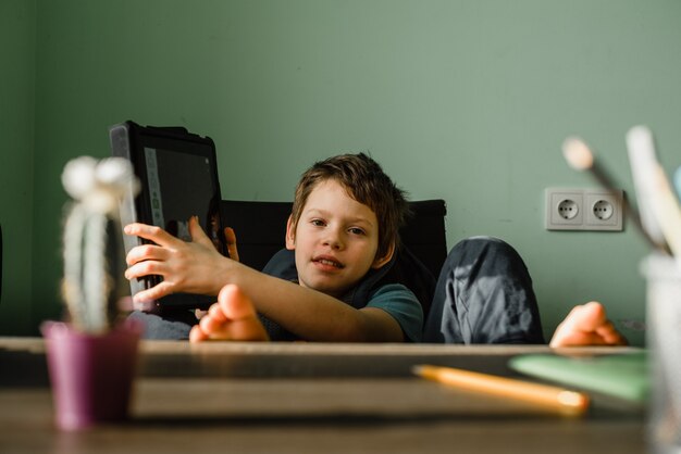 Niño sonriente con tableta en casa