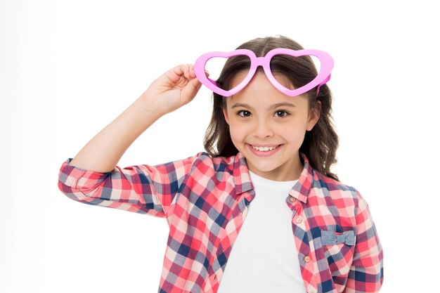 Niño sonrisa encantadora enamorarse Chica anteojos en forma de corazón celebra el día de San Valentín Chica lindo niño cara sonriente anteojos de corazón Concepto de símbolo de amor Enamórate Concepto de amor infantil