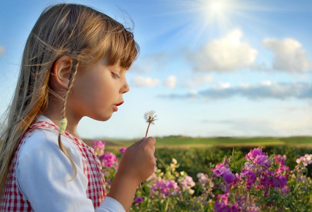 niño soplando en la flor con cara feliz