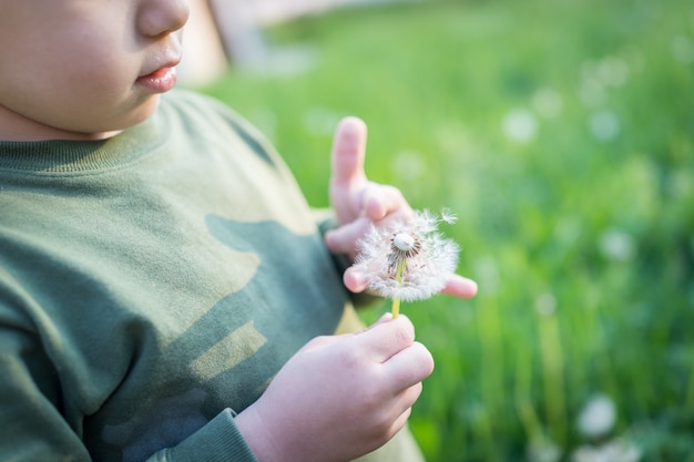 Niño soplando la flor del diente de león