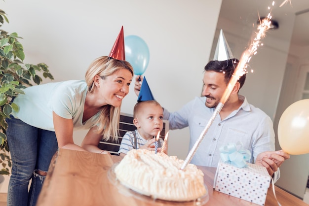 Niño soplando velas con su familia