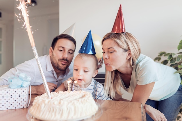 Niño soplando velas con su familia