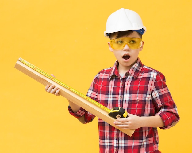 Foto niño sorprendido con cinta métrica