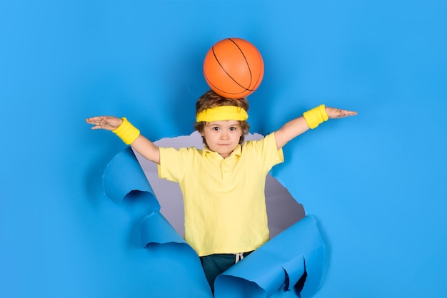 Niño sorprendido sostiene la bola en la cabeza Actividades para niños Equipo deportivo Estilo de vida deportivo activo