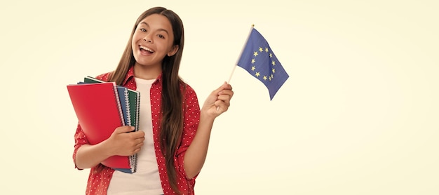 Niño sostenga la bandera de la unión europea y el cuaderno de la escuela para estudiar aislado en la educación blanca