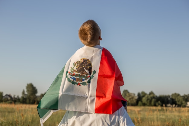 Foto niño sosteniendo la bandera de méxico. 