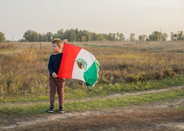 Foto niño sosteniendo la bandera de méxico