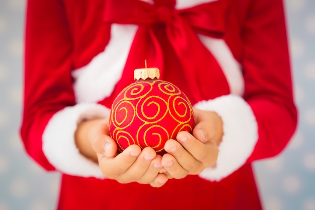 Niño sosteniendo la bola de Navidad. Concepto de vacaciones de Navidad