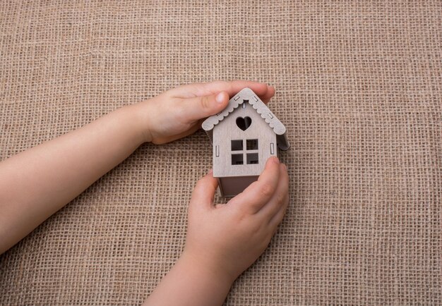 Niño sosteniendo una casa modelo en un lienzo