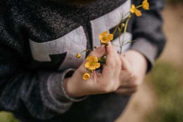 Niño sosteniendo flores amarillas en sus manos