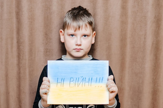 niño sosteniendo una foto con las palabras no a la guerra