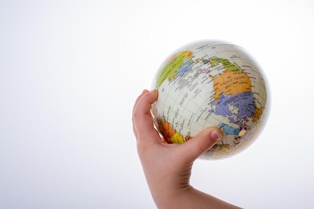 Foto niño sosteniendo un globo terráqueo en la mano