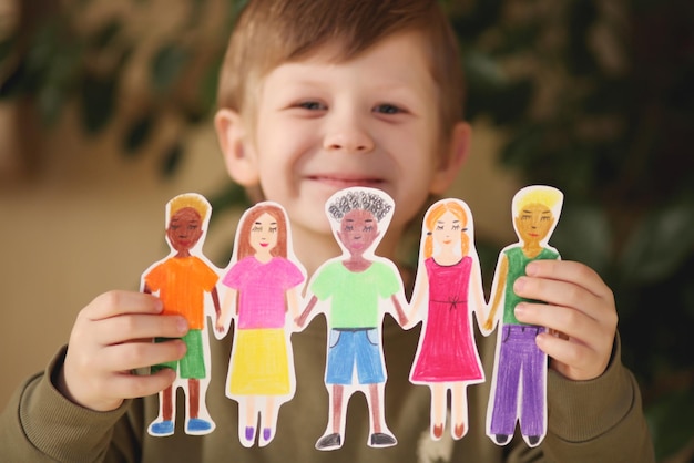 niño sosteniendo guirnaldas caseras de papel de personas de diferentes razas