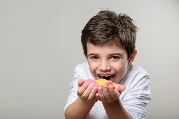 niño sosteniendo un macarrón amarillo