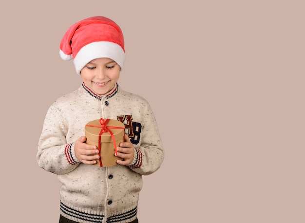 Niño sosteniendo un regalo sobre un fondo beige