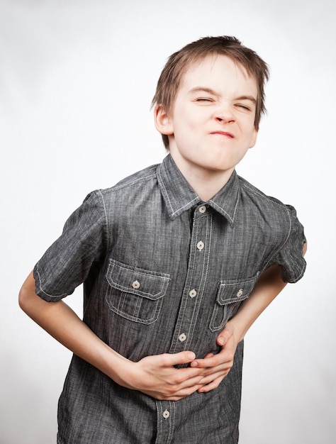 Foto niño sosteniendo su abdomen con dolor de estómago