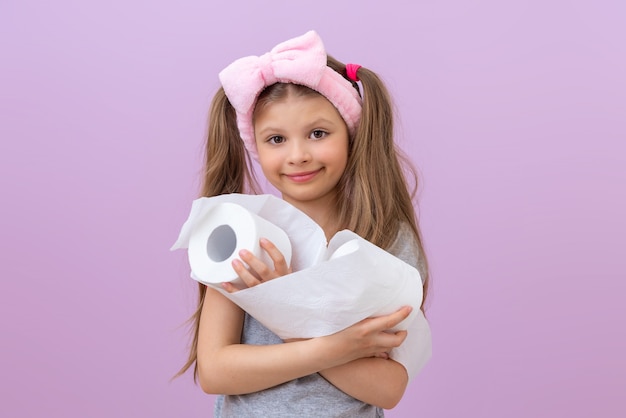 El niño sostiene dos rollos de papel higiénico.