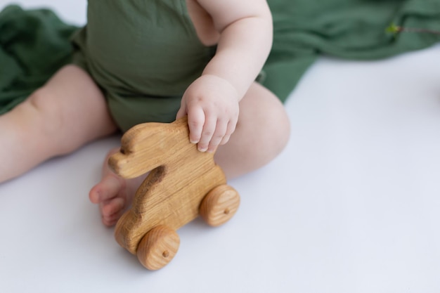 un niño sostiene un juguete de madera liebre de juguete de madera