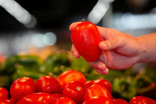 Un niño sostiene un tomate en un mercado.