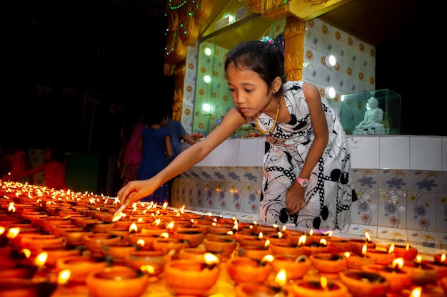 Un niño sostiene una vela para honrar el nacimiento de la iluminación.