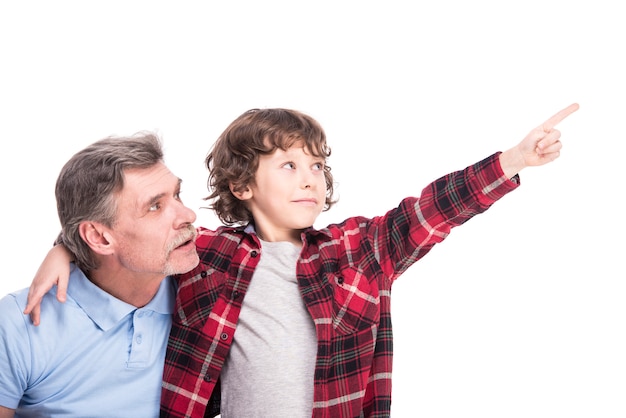 Foto niño con su abuelo, está apuntando a algún lado con la mano.