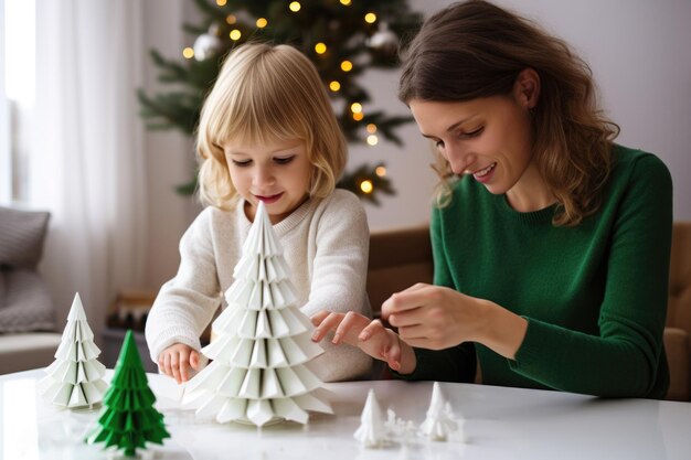El niño y su madre están haciendo artesanías de árboles de Navidad para la Cabalgada de los Magos y la escena de la Natividad