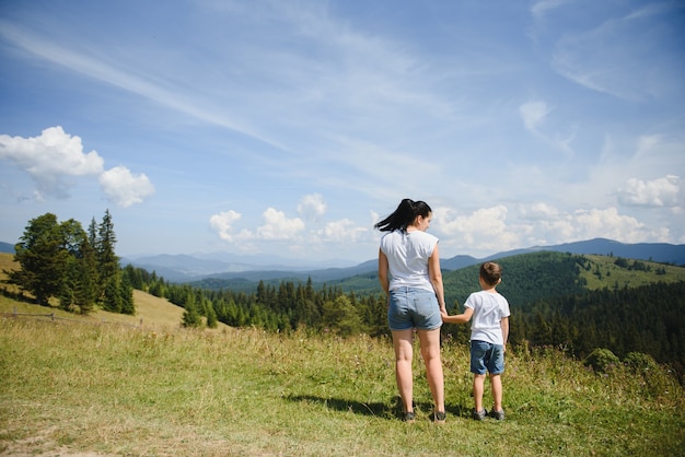 Niño y su madre de pie en una montaña