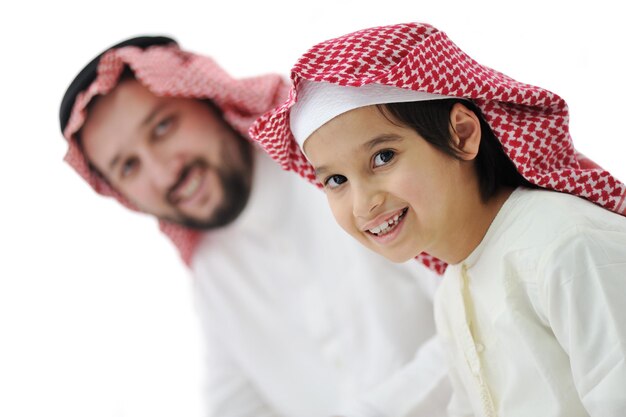 Niño y su padre en ropa tradicional del Medio Oriente