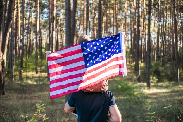 Niño con su padre sosteniendo la bandera americana