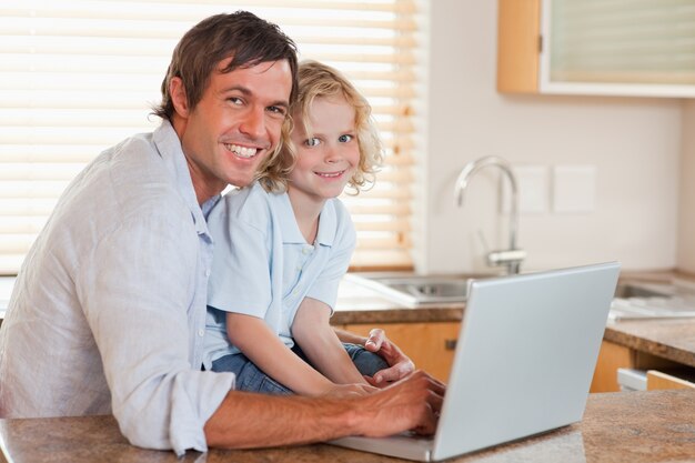 Niño y su padre usando un cuaderno juntos