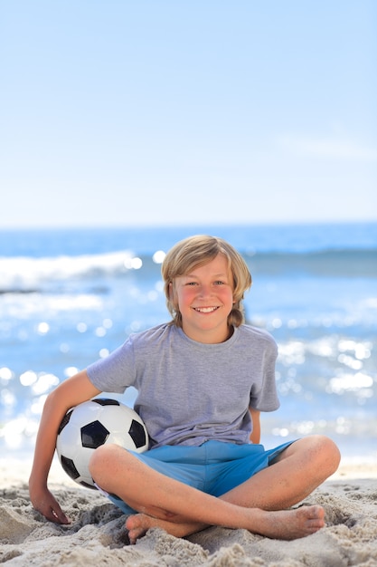 Niño con su pelota en la playa