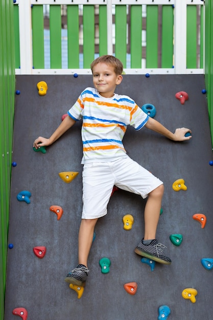 Un niño sube un muro de escalada en un patio moderno