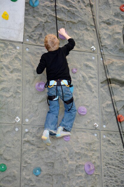 Foto un niño se sube a una pared