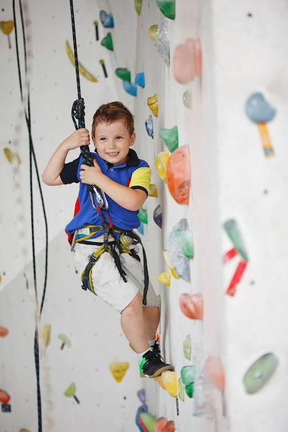 Niño subiendo a un muro alto