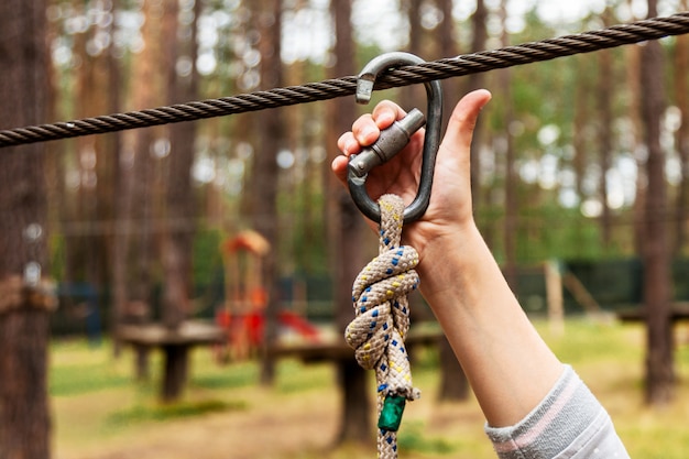 Un niño sujeta una carabina en una cuerda de seguridad.