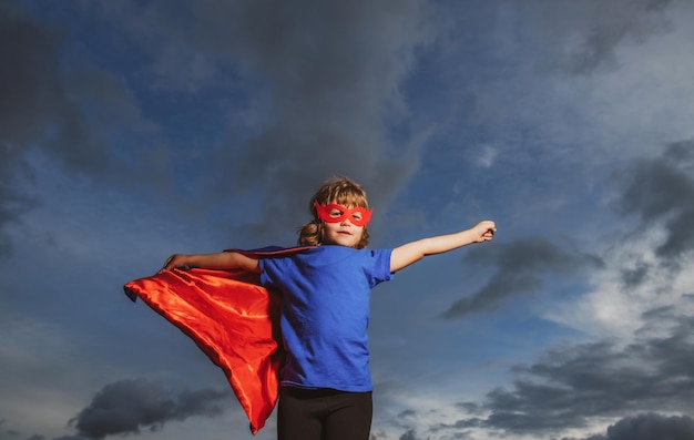 Foto niño superhéroe con concepto de motivación de éxito de capa de héroe