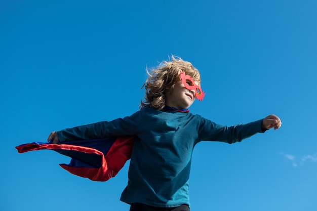 Niño superhéroe en un concepto de superhéroe de capa de superhéroe rojo