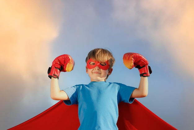 Foto niño superhéroe contra el cielo azul de verano