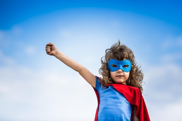 Niño superhéroe contra el fondo de cielo azul