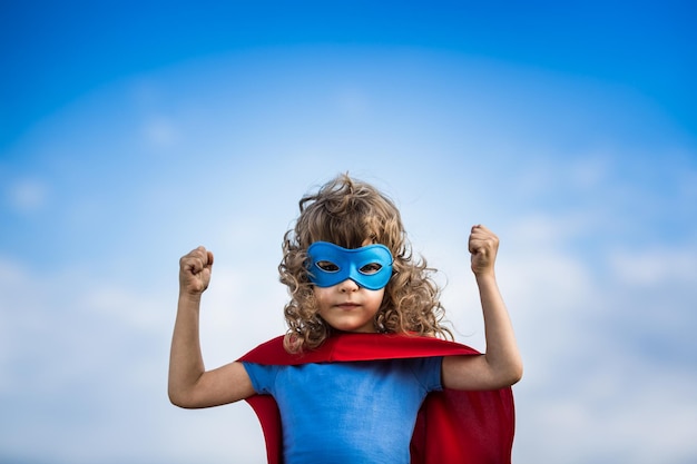 Niño superhéroe contra el fondo de cielo azul