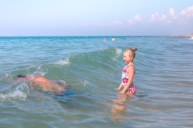 Un niño con sus padres nadar en las olas del mar el padre se sumergió en el agua aventuras en el mar