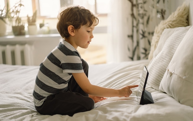 Niño con una tableta en la habitación