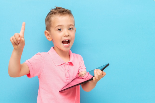 Niño con tableta teniendo idea y apuntando hacia arriba