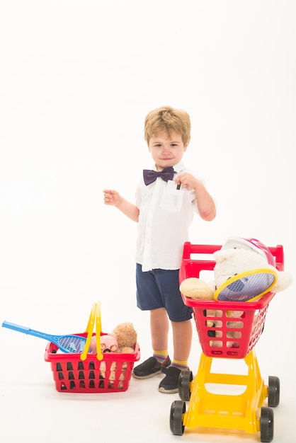 Niño con tarjeta de crédito compras descuento venta concepto niño feliz con carrito de compras y cesta