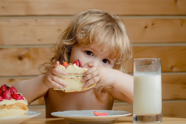 Niño con tarta de fresa y yogur