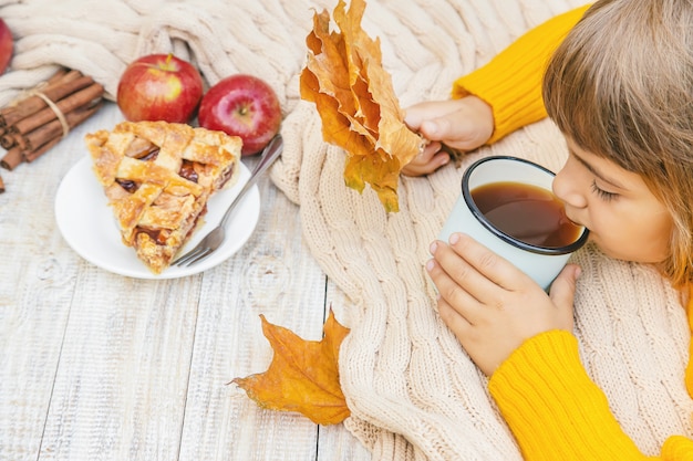 Niño con una taza de té en sus manos.